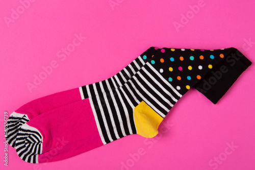 pair of stylish pink socks with patterns, on pink background, fashion and lifestyle concept