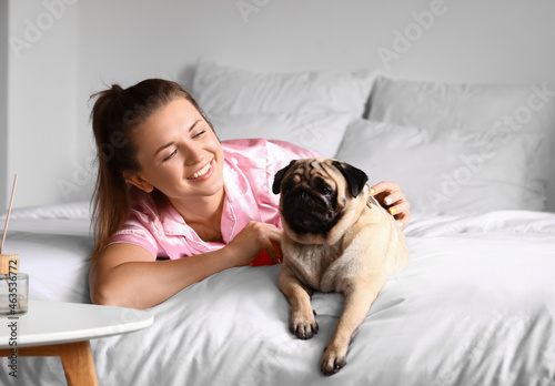 Young woman with cute pug d...