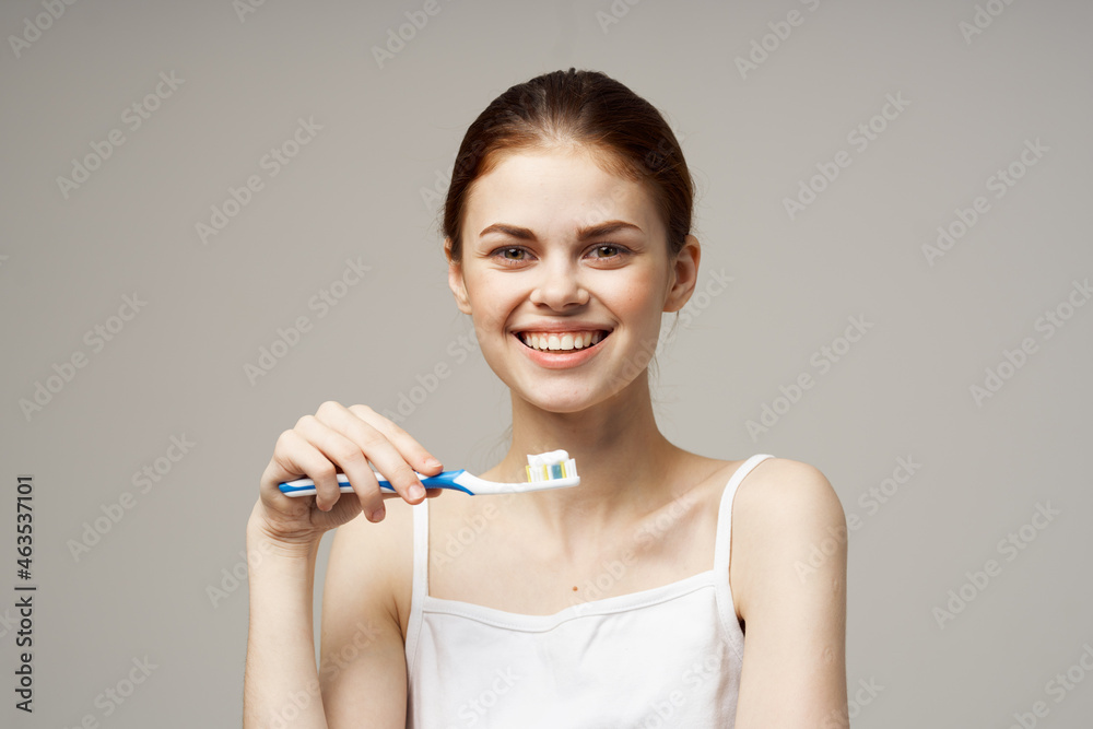 woman in white t-shirt cleans teeth hygiene lifestyle woman in white t-shirt cleans teeth hygiene lifestyle