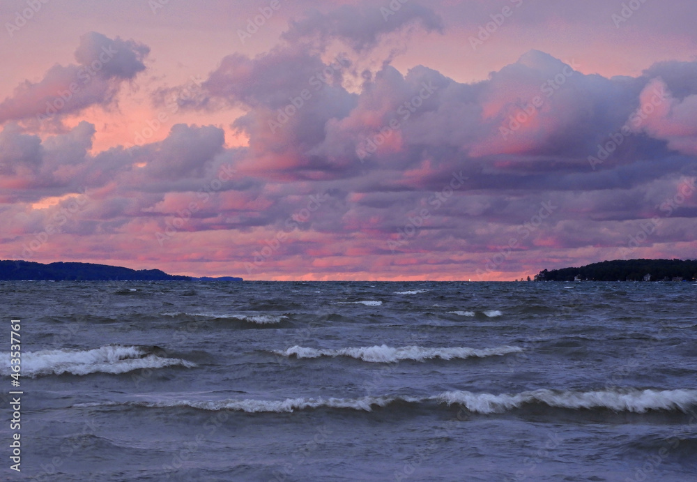 a  pastel sunset across the waves of the  grand traverse bay of  lake michigan, in traverse city, michigan