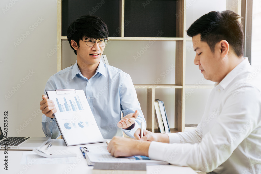 Businessman explaining financial budget figures in report paper to colleagues. Businessman explaining financial budget figures in report paper to colleagues.