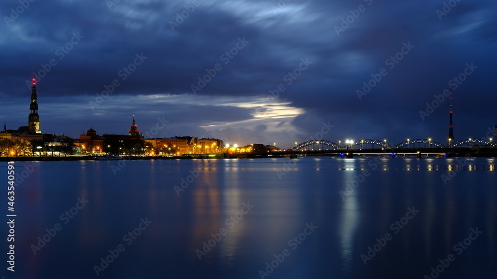 Autumn dawn in blue tones over old Riga reflection of night lights in the Daugava