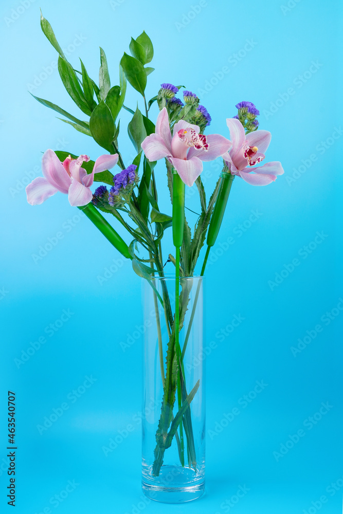 Beautiful bouquet of flowers in a glass vase on a blue background Beautiful bouquet of flowers in a glass vase on a blue background