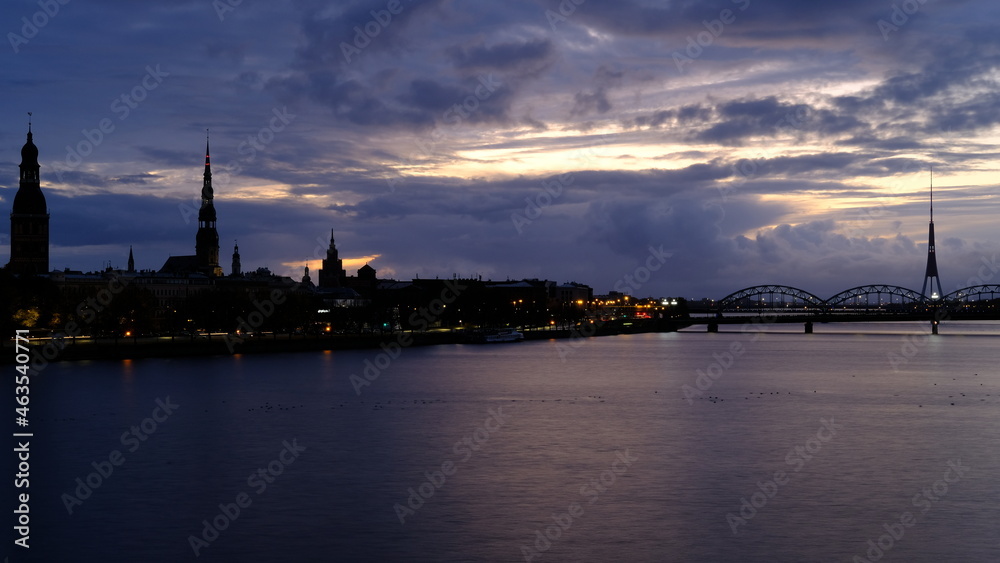 Autumn sunrise in Riga over the Daugava river against the background of the old town and the railway bridge