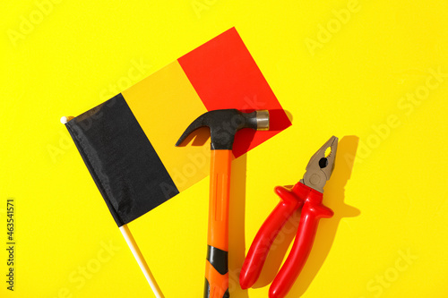 Flag of Belgium and tools on color background. Labor Day celebration photo