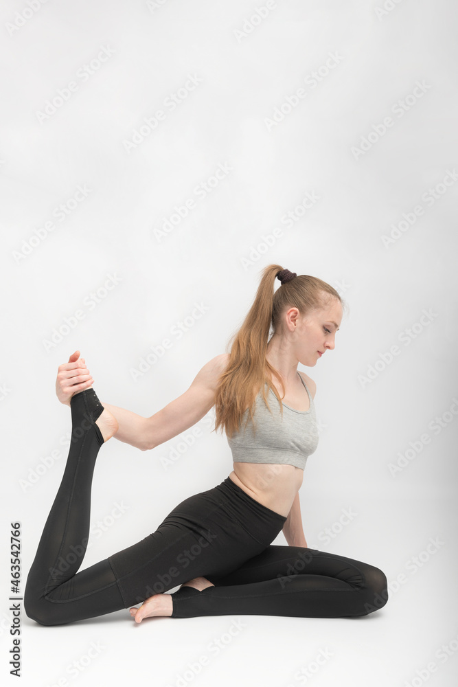 Eka Pada Rajakapotasana. Pigeon Pose. Young slender woman practices yoga. Gymnast training. Exercises to develop flexibility. Eka Pada Rajakapotasana. Pigeon Pose. Young slender woman practices yoga. Gymnast training. Exercises to develop flexibility.