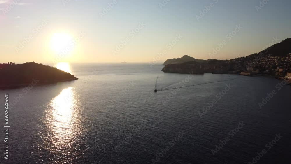 Aerial shot at sunset of the Adriatic Sea and Dubrovnik coast with a boat Aerial shot at sunset of the Adriatic Sea and Dubrovnik coast with a boat