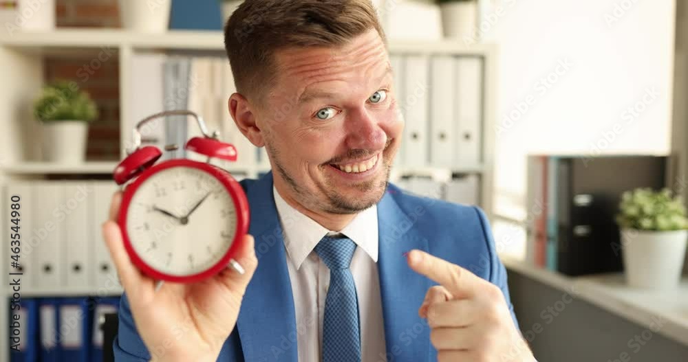 Portrait of smiling manager holding red alarm clock for ten in morning 4k movie