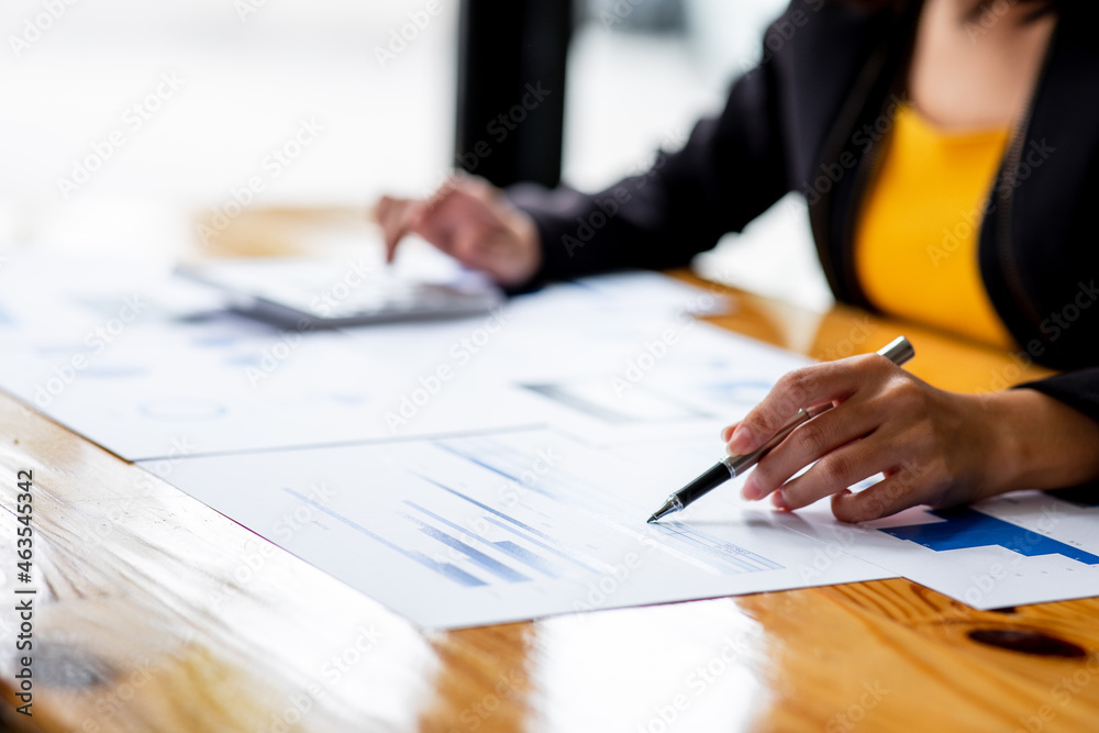 A Businesswoman hand using a calculator with documents financial statistic stock photo,discussion and analysis data the charts and graphs.Market research reports Accounting Finance concept A Businesswoman hand using a calculator with documents financial statistic stock photo,discussion and analysis data the charts and graphs.Market research reports Accounting Finance concept