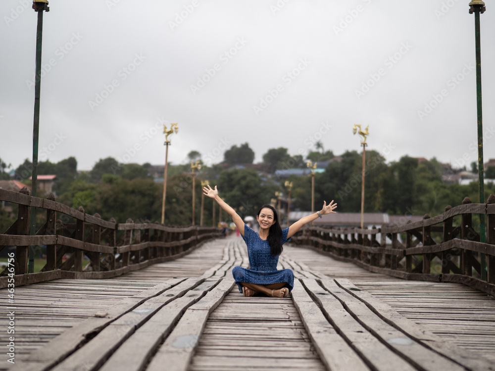 Young beautiful asian woman at Auttamanusorn Wooden Bridge (Sapan Mon) Kanchanaburi , Thailand when she have holiday vacation