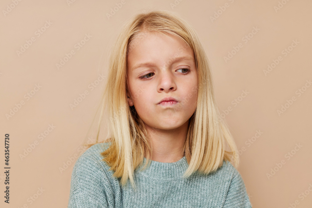 Beautiful little girl in a sweater, grimaces cropped view Beautiful little girl in a sweater, grimaces cropped view