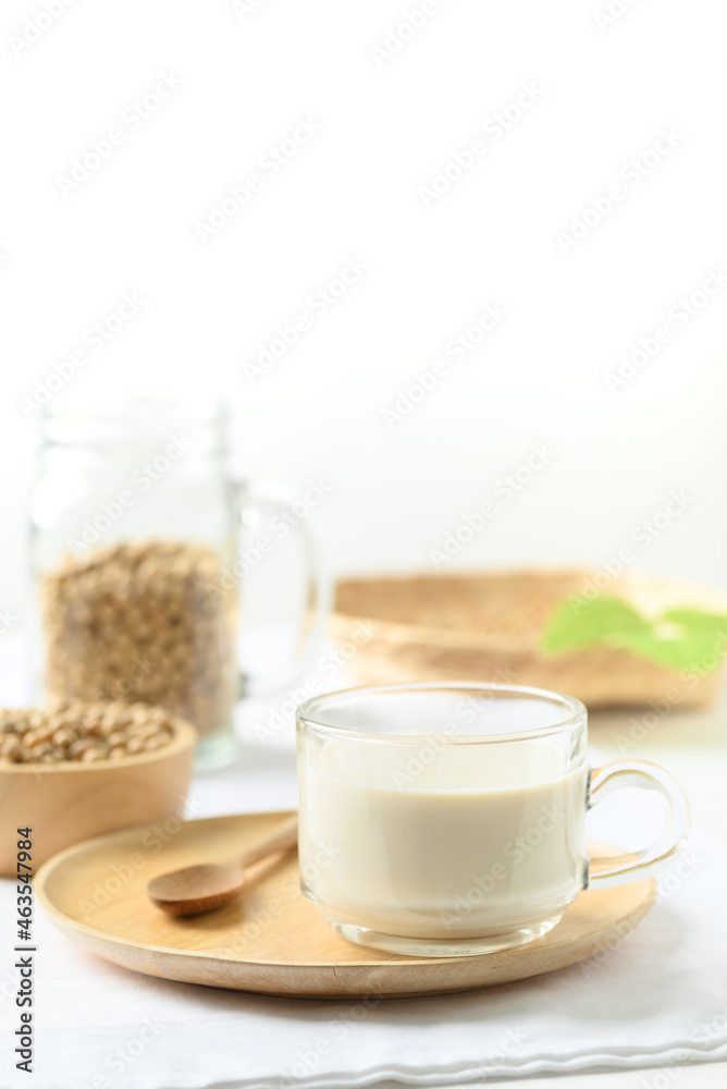 Soy milk in a cup glass with spoon on wooden plate with white background, Healthy drink Soy milk in a cup glass with spoon on wooden plate with white background, Healthy drink