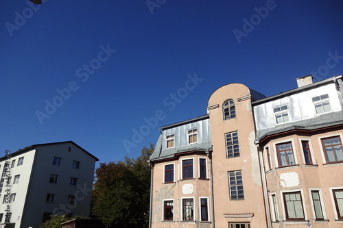 Close up of one renovated and one old house at Mulla street in Pelgulinna. Clear blue sky background with some autumn foliage on the back. Bottom up view. Tallinn, Estonia, Europe. September 2021. photo