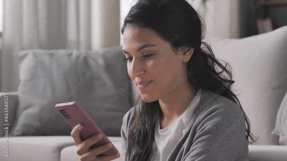 side view portrait of young brunette latina woman using smart phone mobile at home,hispanic smiling female holding smartphone browsing internet online indoors