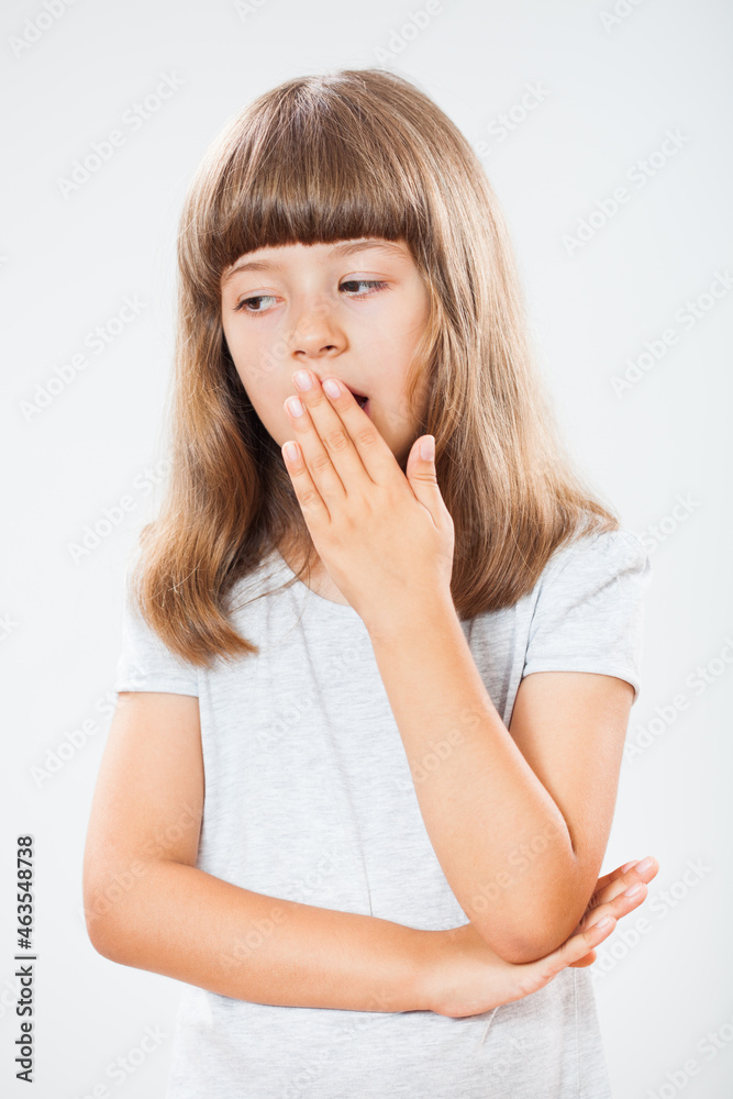 Studio shot portrait of little girl who is tired and yawning. Copy space on gray background. Studio shot portrait of little girl who is tired and yawning. Copy space on gray background.