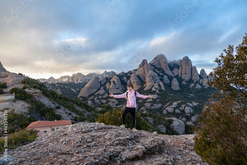 The young man looks at the mountains. Landscape with mountains and tourist Montserrat Spain.