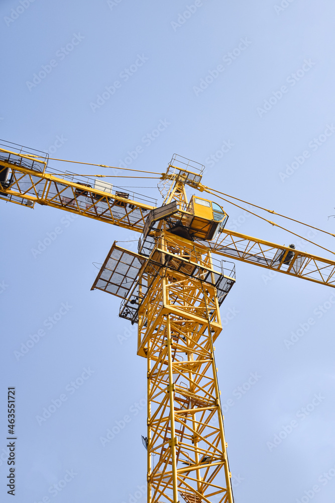 Tower crane at the construction site, against the blue sky Tower crane at the construction site, against the blue sky