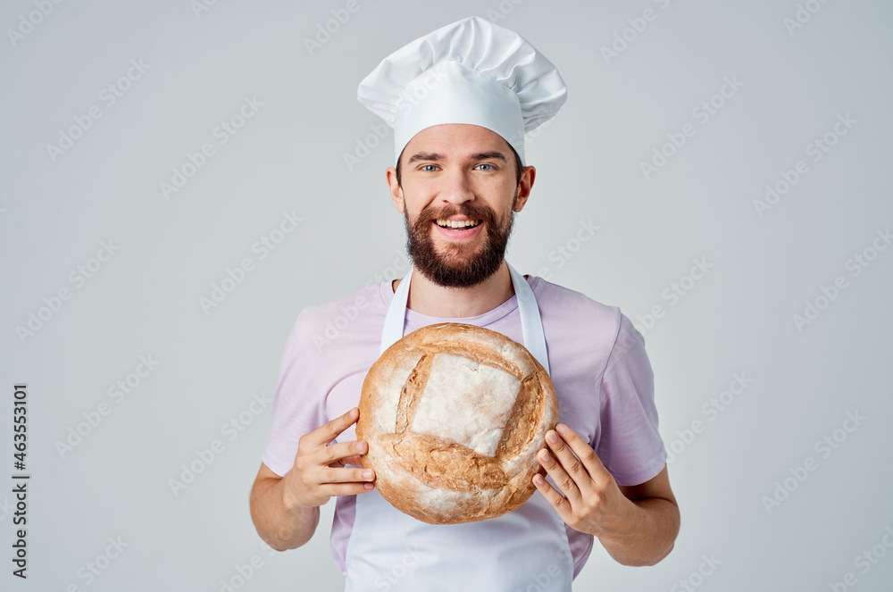a man in a cook's uniform with bread in his hands baking cooking work a man in a cook's uniform with bread in his hands baking cooking work