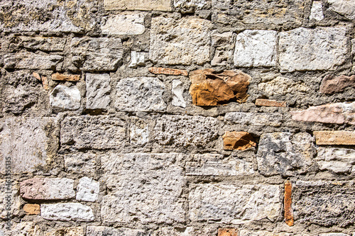 Stone antique old wall as a background or texture. Vintage background of a fortress wall in loft and grunge style with place for text and copy space. photo