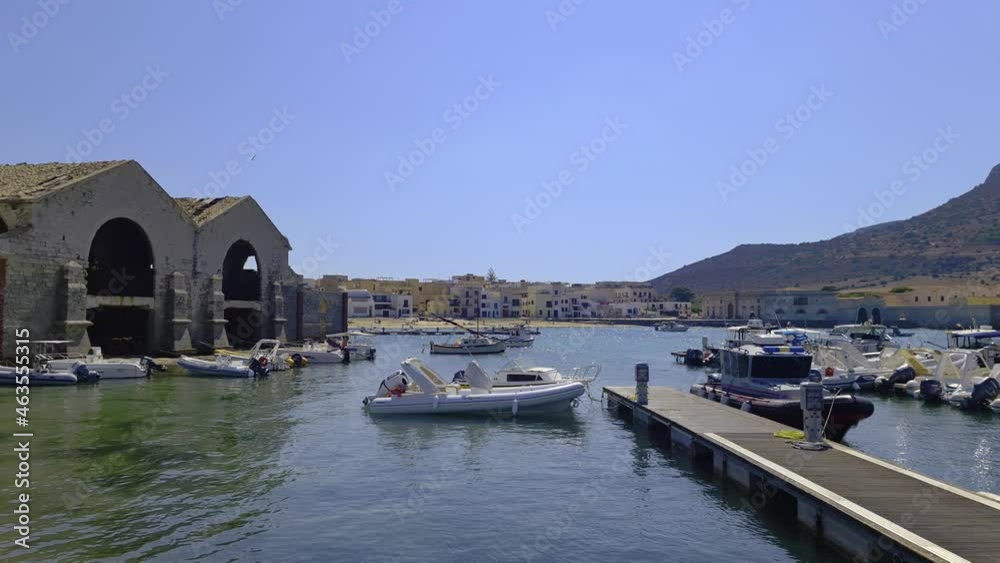 Famous Florio tuna factory or tonnara at port of Favignana and Santa Caterina castle on top of mountain, Italy. Slow-motion panning Famous Florio tuna factory or tonnara at port of Favignana and Santa Caterina castle on top of mountain, Italy. Slow-motion panning