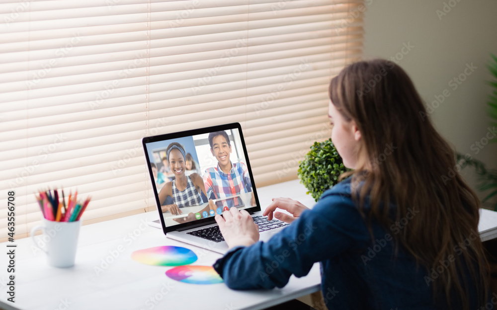 Caucasian girl using laptop for video call, with smiling diverse high school pupils on screen Caucasian girl using laptop for video call, with smiling diverse high school pupils on screen