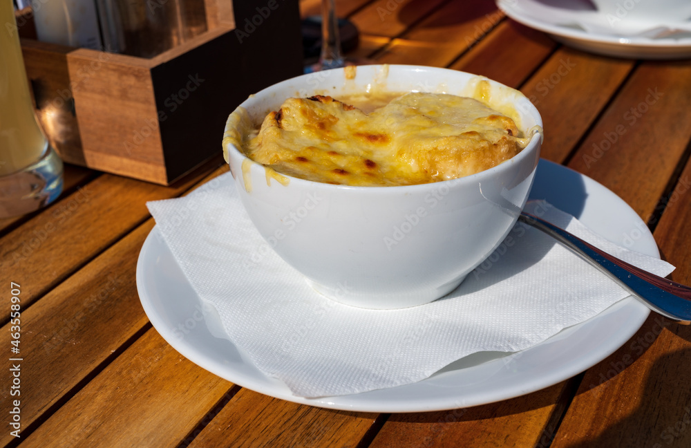 French caramelized onion soup with croutons and gruyere cheesse from oven