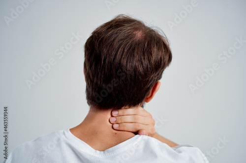 man in a white t-shirt stress medicine pain in the neck studio treatment