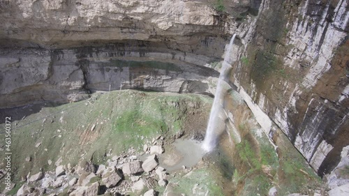 High waterfall flowing among the stone walls of a deep canyon. Republic of Dagestan, Russia. The concept of traveling in your country