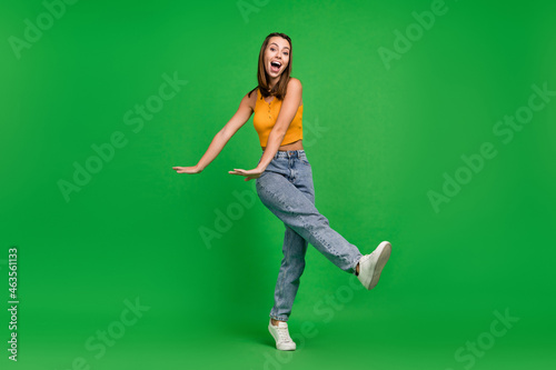 Full size photo of millennial funky brunette lady dance wear top jeans shoes isolated on green color background