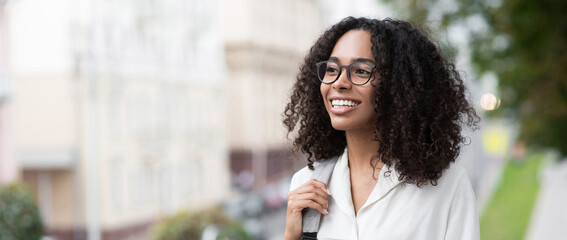 Young beautiful woman smiling in a city panoramic banner,  pretty student girl portrait, young businesswoman standing outdoor, copy space