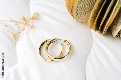 Photography Golden modern bijouterie earrings on white background.