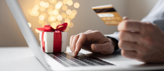 Man using laptop computer and credit card ordering Christmas gift panoramic banner, Shopping online during holidays, internet banking, store online, payment, spending money, holiday concept.