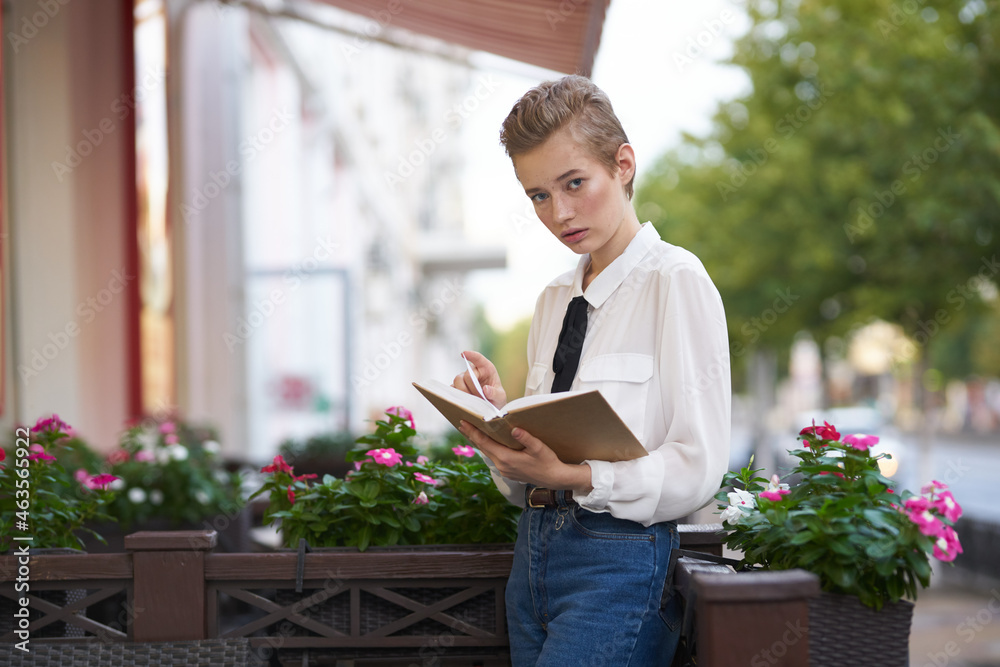 student with a book in his hands outdoors in a summer cafe rest Lifestyle student with a book in his hands outdoors in a summer cafe rest Lifestyle