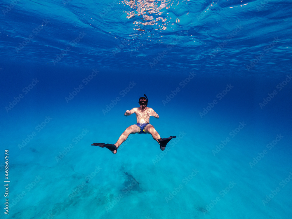 Underwater photo of man free diving in clear sea