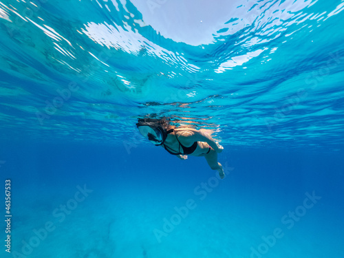 Beautiful woman swimming underwater with mask