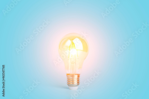 Knowledge and idea concept. Light bulb with light on a blank blue background. Brain, wisdom, knowledge and energy conservation is a creative idea.