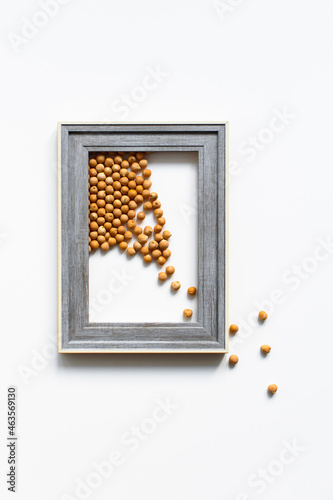 Chickpeas or garbanzo beans in a blue wooden frame with white edging on a white background with place for text. Healthy and vegetarian food. Flat lay isolate