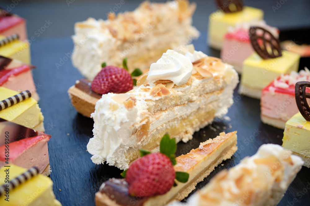 Tarta de crema, merengue y frutas del bosque en buffet sobre pizarra