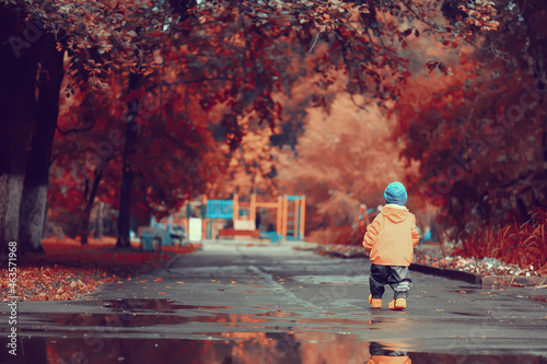 autumn in the park little boy walking in a raincoat seasonal look