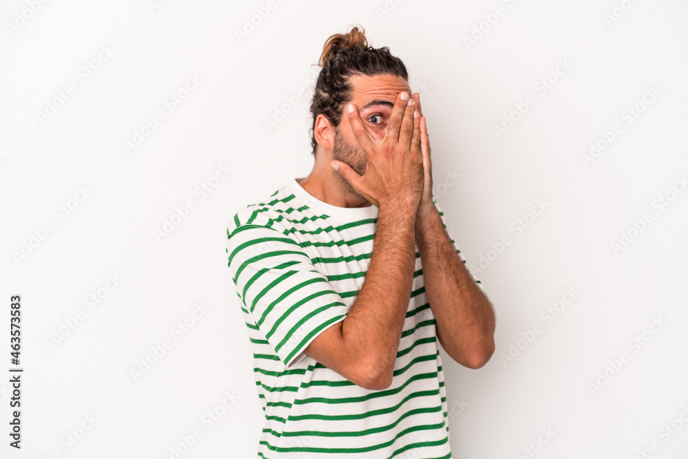 Young caucasian man isolated on white background blink through fingers frightened and nervous. Young caucasian man isolated on white background blink through fingers frightened and nervous.