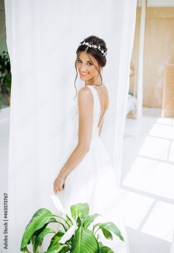 Morning of the bride. Beautiful young woman in white dress in the morning