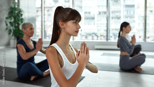 Young woman do sports train meditate at yoga class