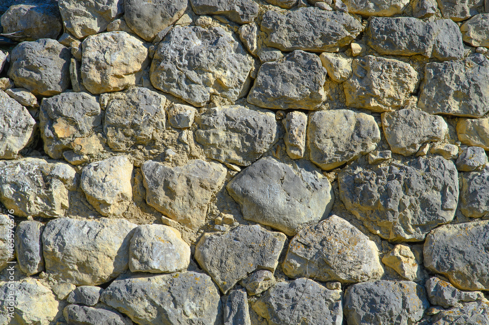 Fragment of an old wall made of large hewn stone blocks