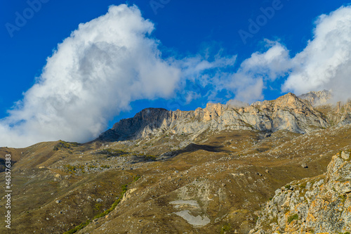 Fototapeta Naklejka Na Ścianę i Meble -  Mountain landscape with snow-capped peaks against the blue sky
