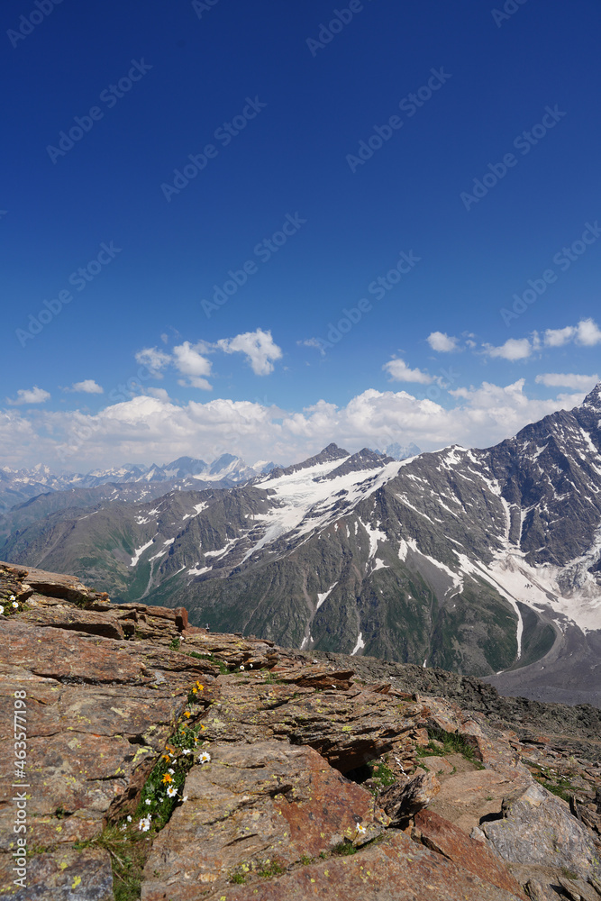 View from a brown stone ledge to a distant snowy peak