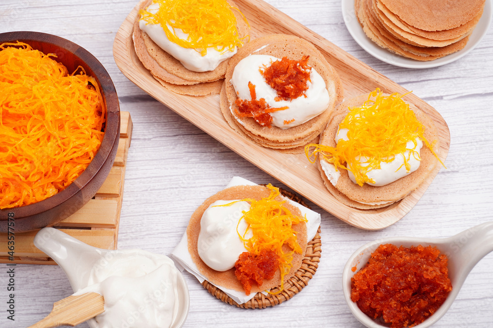 Thai dessert crepes or kanom bueng Ancient Thai desserts, gold egg yolk thread cakes, coconut cream Thai dessert crepes or kanom bueng Ancient Thai desserts, gold egg yolk thread cakes, coconut cream