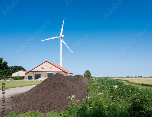 farm barn in wieringermeer near wind turbine under blue sky © ahavelaar