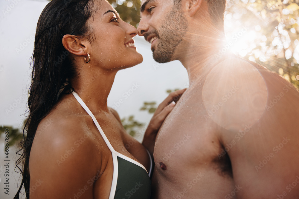 Couple touching their noses under an outdoor shower Couple touching their noses under an outdoor shower