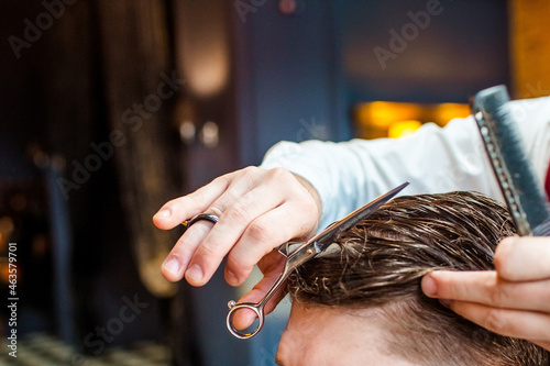 barbershop, the master does his hair, in the frame the hands of the master with the tool