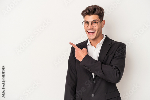 Young business caucasian man isolated on white background smiling and pointing aside, showing something at blank space.